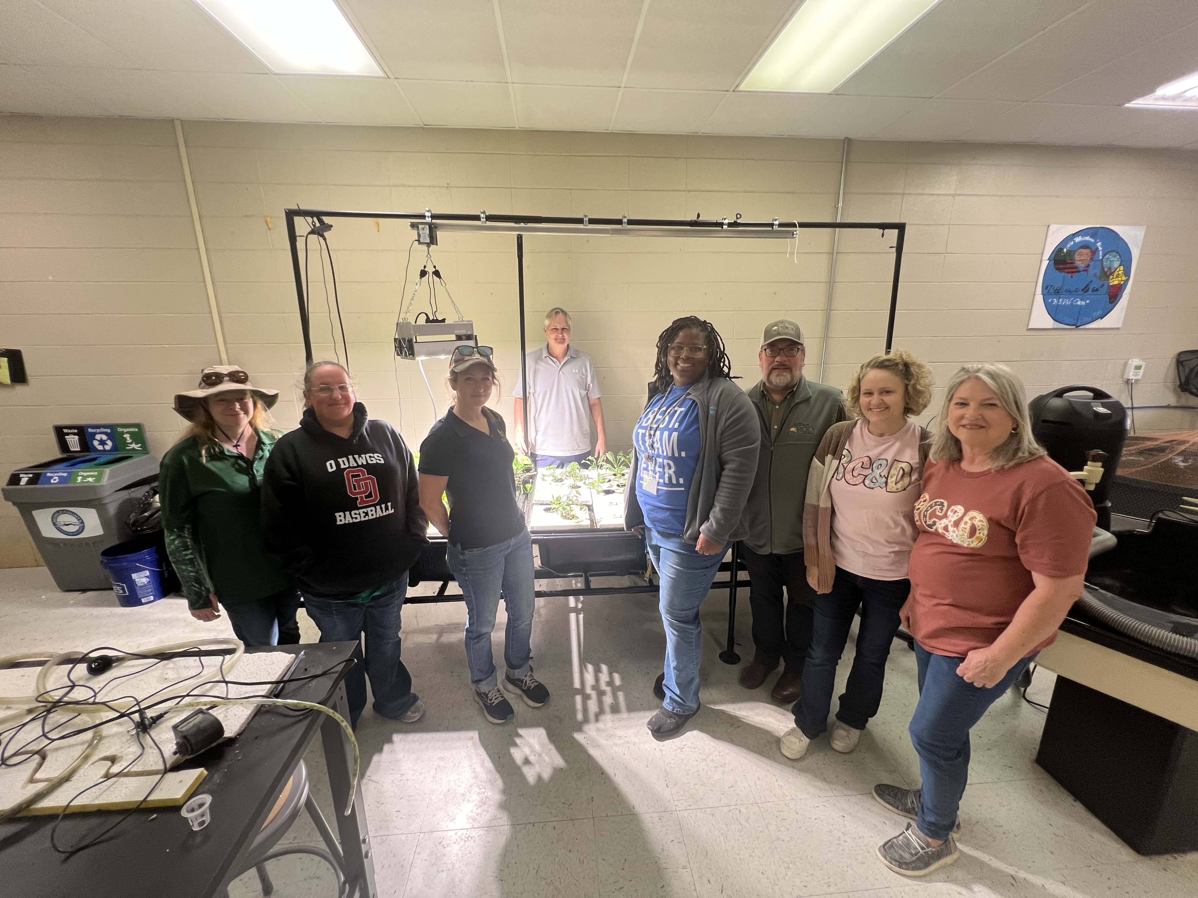 The RC&D team gathered around an indoor grow-light seedling station